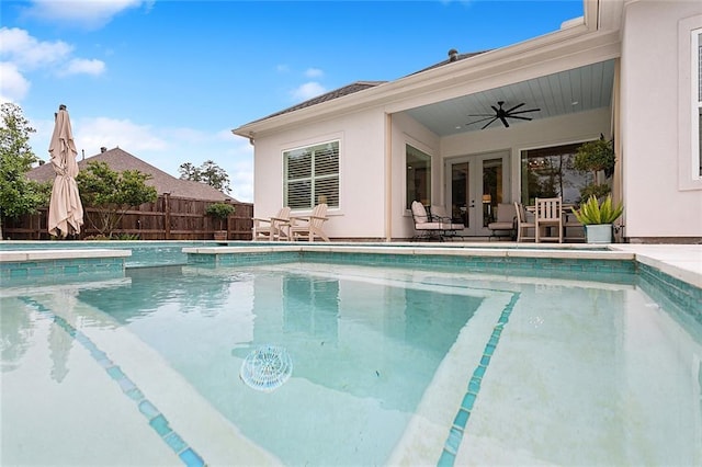 view of swimming pool with ceiling fan and french doors