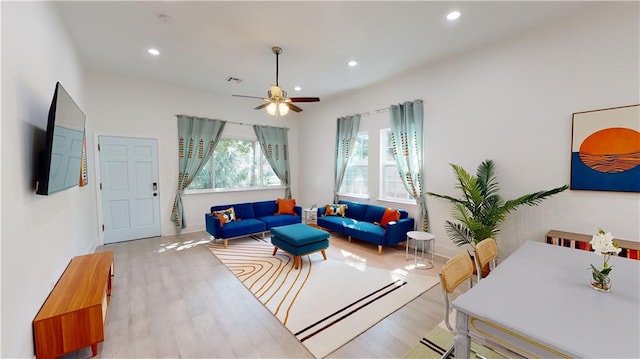 living room featuring ceiling fan and light hardwood / wood-style flooring