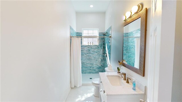 bathroom featuring a tile shower, vanity, toilet, and tile patterned floors