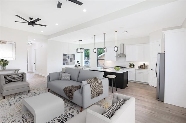 living room featuring sink, ceiling fan, and light hardwood / wood-style floors