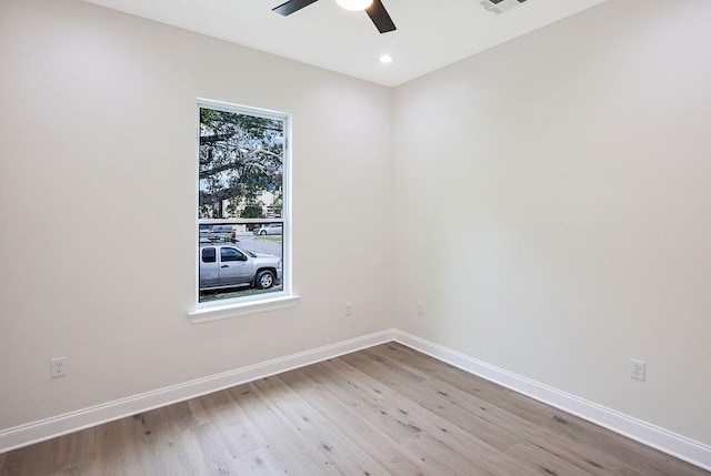 empty room with ceiling fan and light hardwood / wood-style flooring