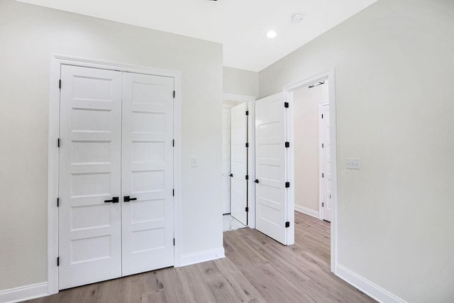 unfurnished bedroom with light hardwood / wood-style floors and a closet