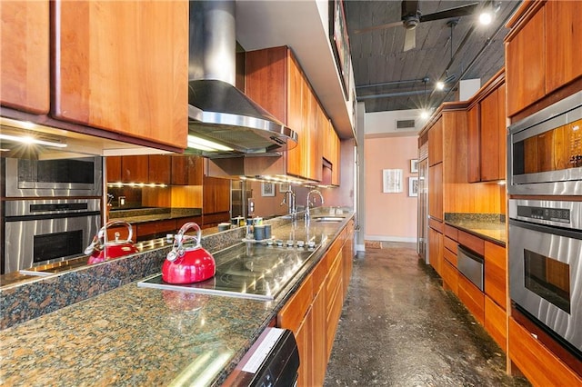 kitchen with appliances with stainless steel finishes, sink, ceiling fan, and wall chimney range hood