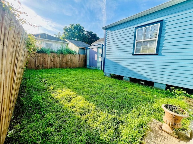 view of yard with an outbuilding, a storage shed, and fence