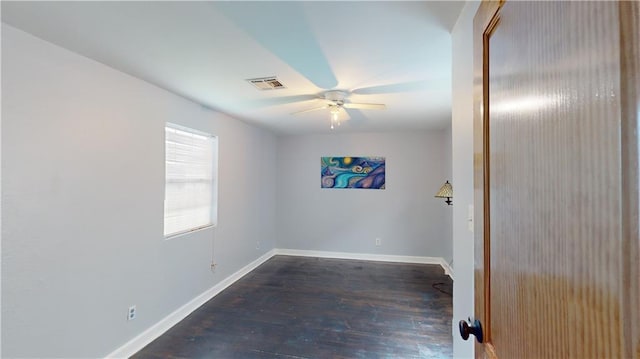 spare room featuring dark wood-type flooring and ceiling fan