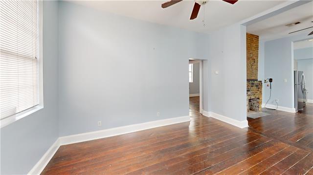 spare room with baseboards, ceiling fan, and hardwood / wood-style floors