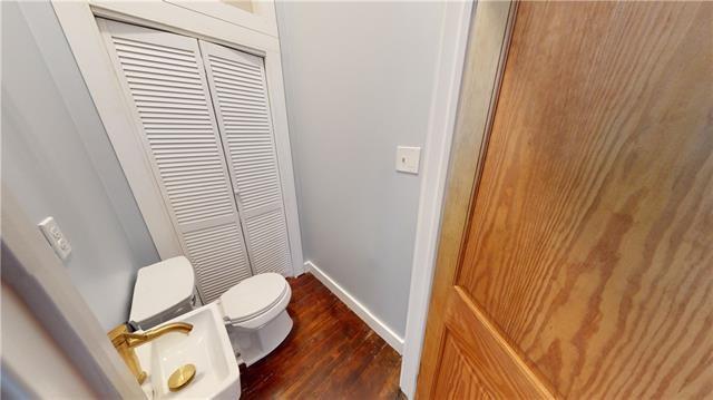 bathroom featuring toilet, baseboards, and wood finished floors