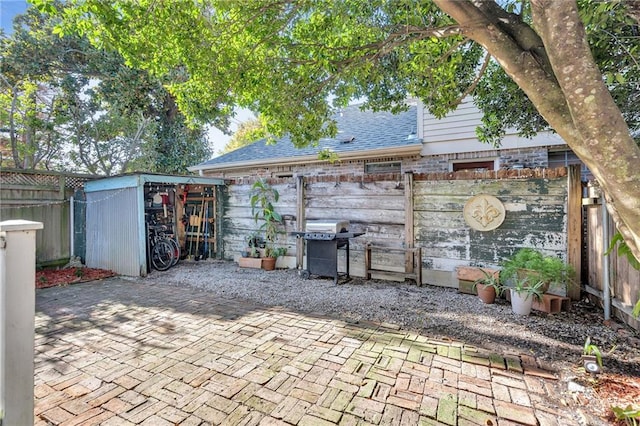 view of patio with a grill and a storage shed