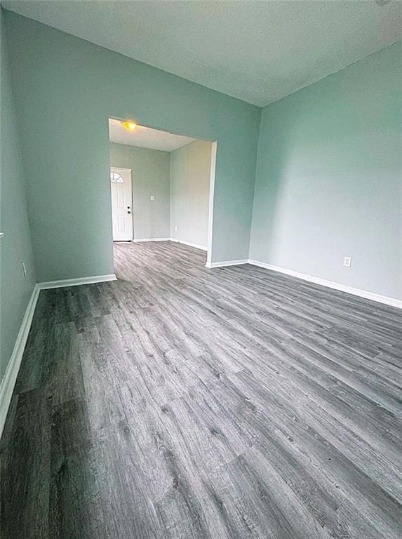 empty room with a textured ceiling and dark wood-type flooring