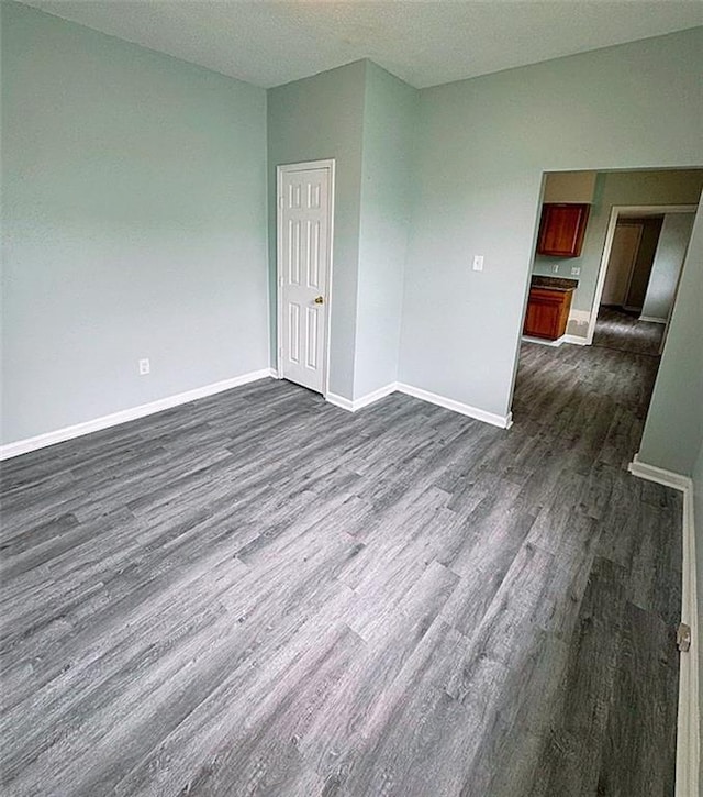 spare room featuring a textured ceiling and dark wood-type flooring