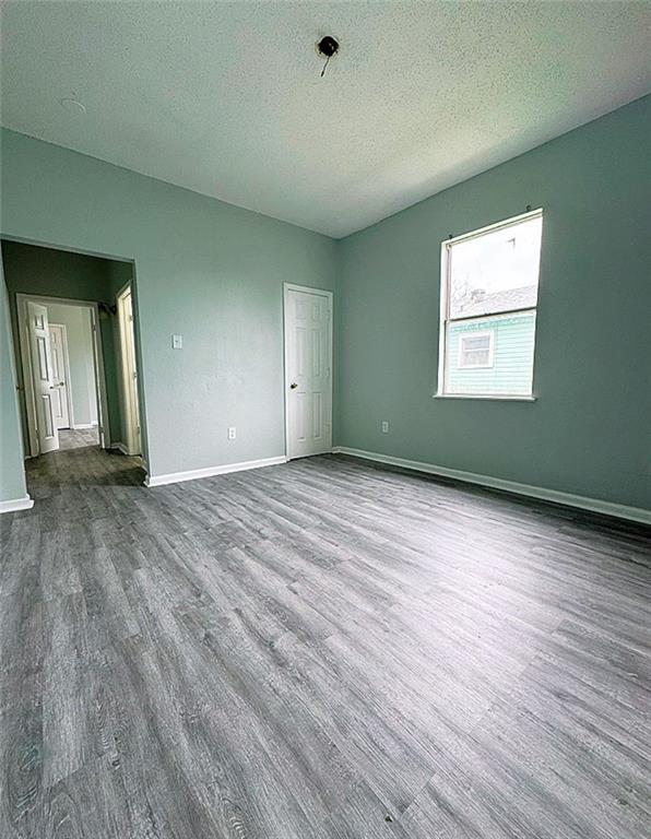 empty room featuring a textured ceiling and hardwood / wood-style flooring