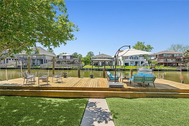 dock area with a lawn and a water view