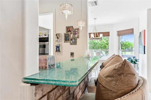 kitchen with decorative light fixtures, oven, a notable chandelier, and visible vents