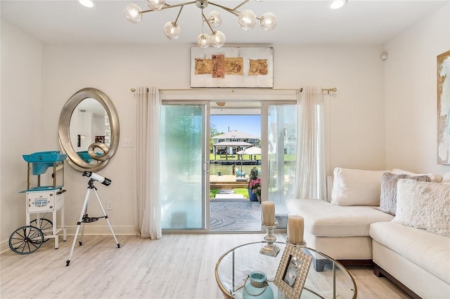 living room featuring an inviting chandelier, baseboards, wood finished floors, and recessed lighting