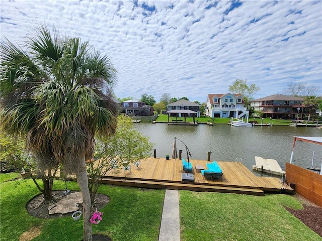 view of dock featuring a yard, a water view, and a residential view