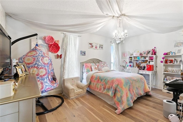 bedroom featuring a textured ceiling, baseboards, and wood finished floors