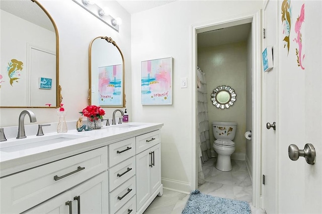 full bathroom with marble finish floor, double vanity, a sink, and toilet