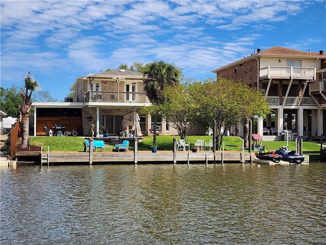 view of dock with a water view and a lawn