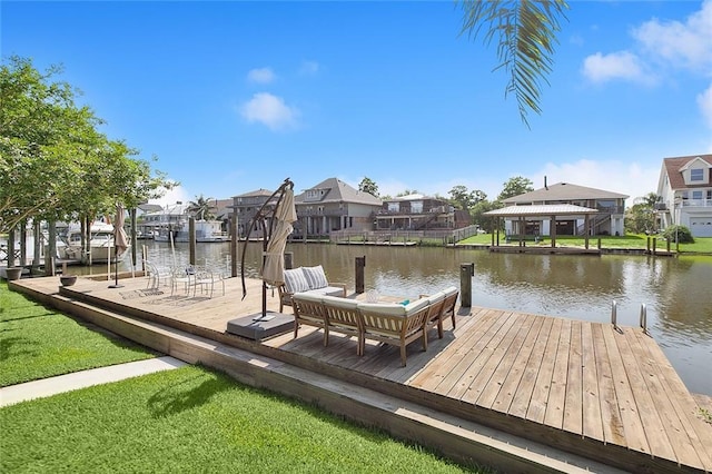 dock area with a residential view, a water view, and a yard