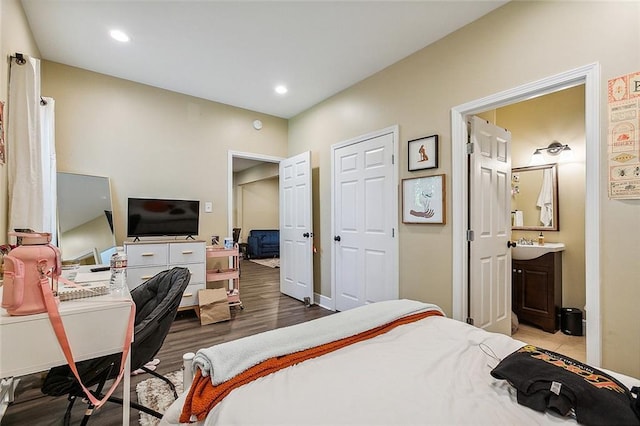 bedroom featuring ensuite bath and wood-type flooring