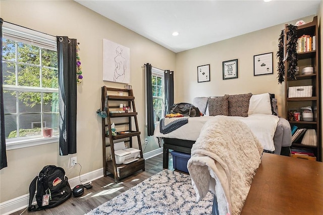 bedroom featuring multiple windows and dark wood-type flooring