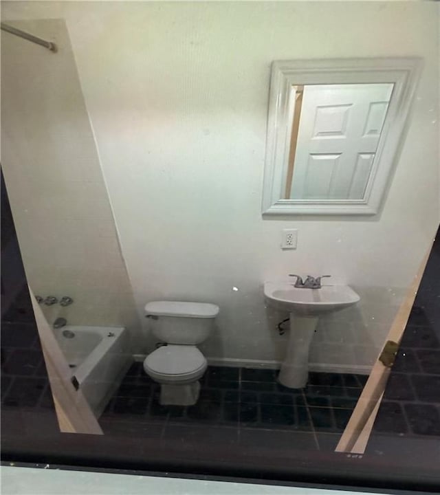 bathroom featuring tile patterned flooring, a bath, and toilet