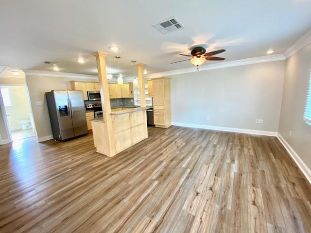 kitchen featuring stainless steel appliances, light hardwood / wood-style flooring, decorative light fixtures, light brown cabinetry, and ornamental molding