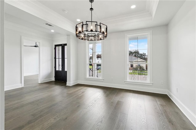 unfurnished dining area with a raised ceiling, dark hardwood / wood-style floors, ceiling fan with notable chandelier, and ornamental molding