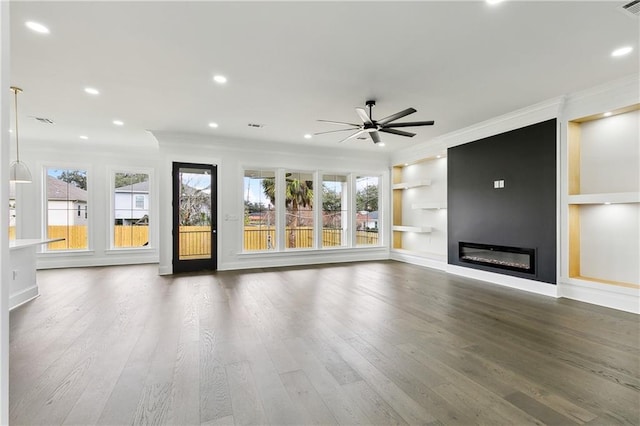 unfurnished living room featuring ceiling fan, crown molding, and dark hardwood / wood-style floors