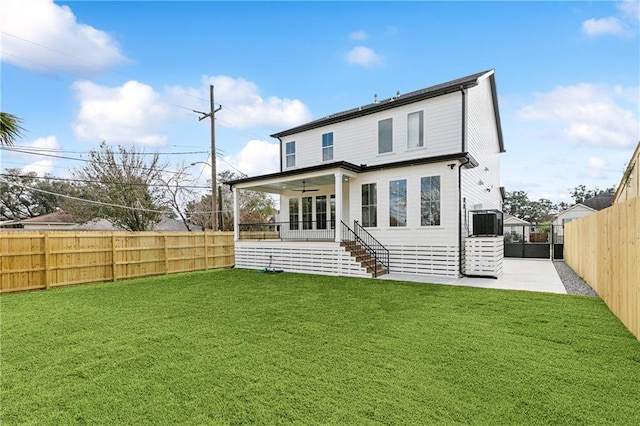 back of property with a lawn, ceiling fan, central AC unit, and a patio area