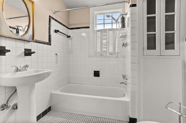 bathroom featuring sink, tile walls, and tiled shower / bath combo