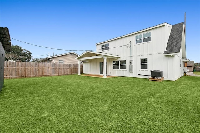 back of house with cooling unit and a lawn