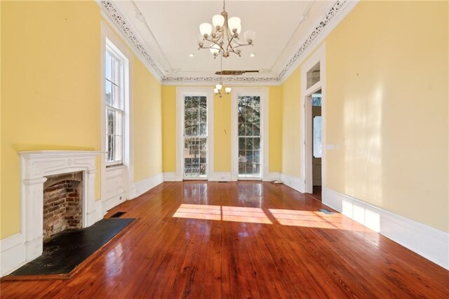 1432 Magazine St, New Orleans, LA 70130 - unfurnished living room with wood-type flooring, crown molding, and an inviting chandelier