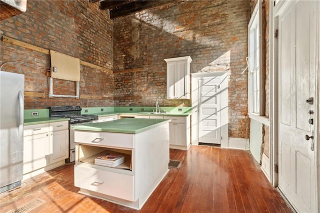 1432 Magazine St, New Orleans, LA 70130 - kitchen featuring appliances with stainless steel finishes, sink, white cabinets, light hardwood / wood-style floors, and a kitchen island