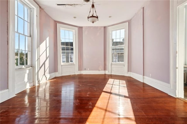 1432 Magazine St, New Orleans, LA 70130 - empty room with a wealth of natural light and dark hardwood / wood-style floors