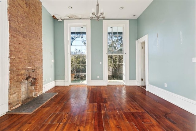 1432 Magazine St, New Orleans, LA 70130 - unfurnished room featuring a chandelier, a fireplace, and wood-type flooring