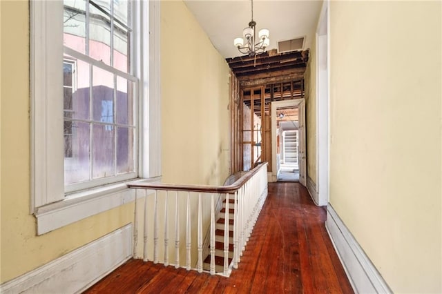 1432 Magazine St, New Orleans, LA 70130 - hall featuring dark hardwood / wood-style floors, a baseboard radiator, and an inviting chandelier