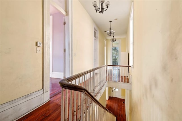 1432 Magazine St, New Orleans, LA 70130 - hallway featuring dark wood-type flooring and an inviting chandelier