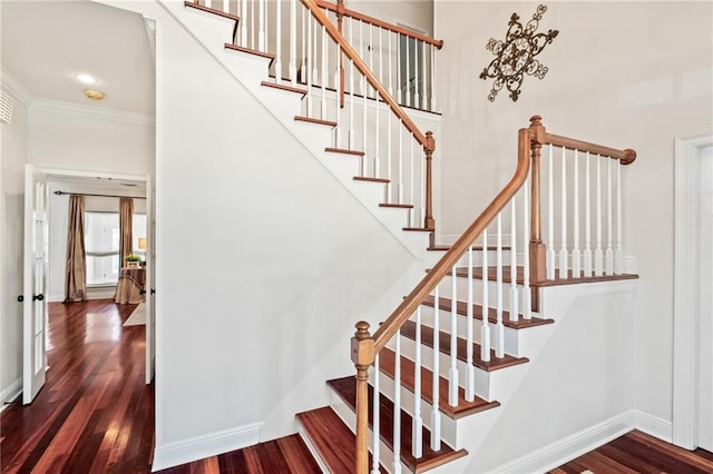 staircase featuring ornamental molding and hardwood / wood-style floors