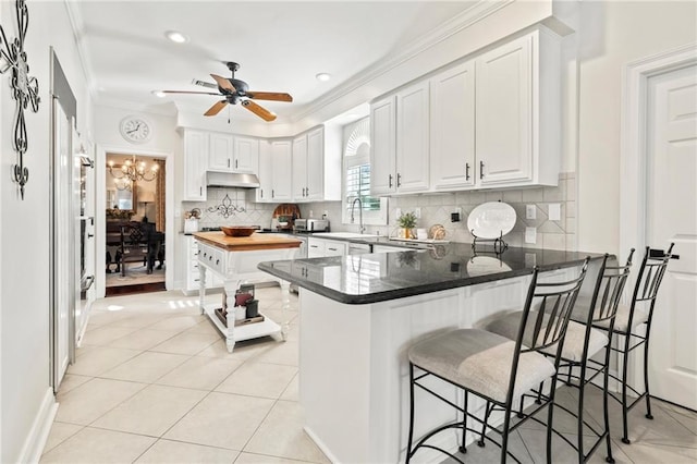 kitchen with white cabinetry, a breakfast bar, and kitchen peninsula