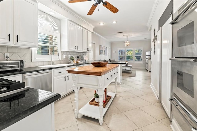 kitchen with sink, crown molding, white cabinets, and appliances with stainless steel finishes