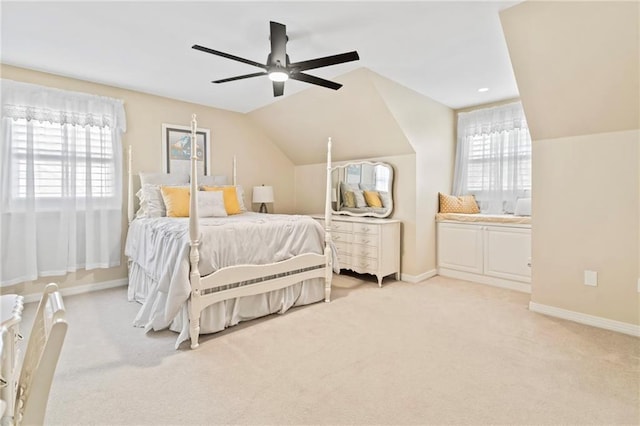 bedroom with multiple windows, vaulted ceiling, light colored carpet, and ceiling fan