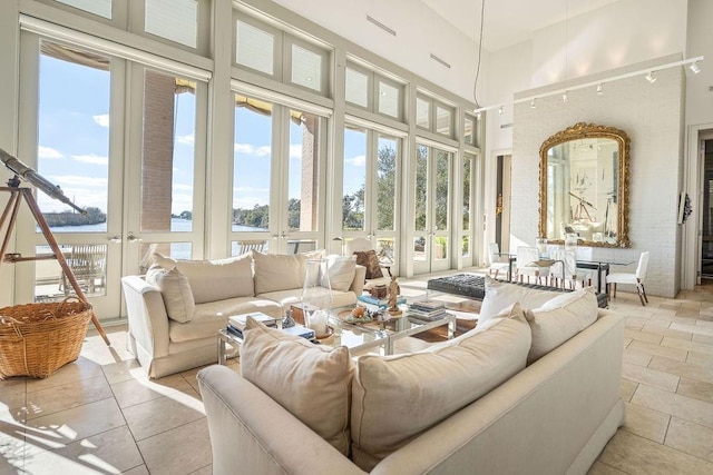 sunroom with a healthy amount of sunlight, a water view, and french doors