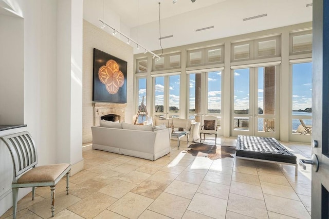 sunroom with a wealth of natural light, french doors, and a water view