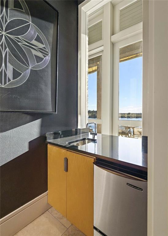 kitchen featuring dishwasher, sink, light tile patterned floors, and a healthy amount of sunlight