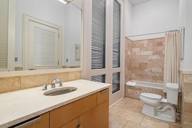 full bathroom with tile patterned flooring, vanity, tiled shower / bath combo, and toilet