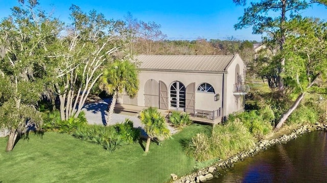 back of house featuring a yard and a water view