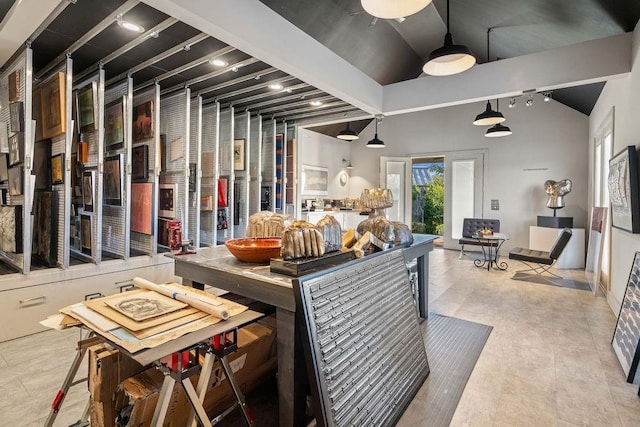 interior space with rail lighting and vaulted ceiling