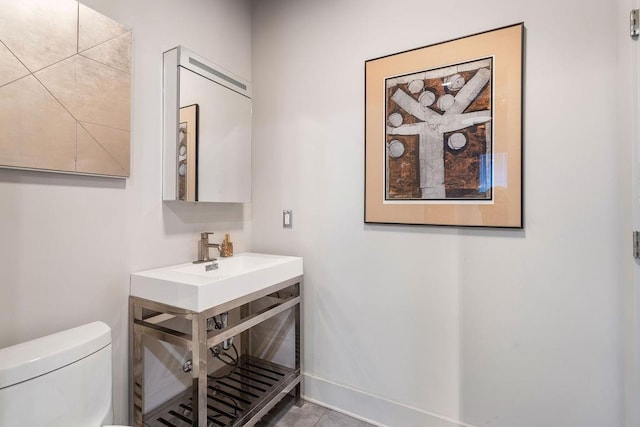 bathroom featuring sink, tile patterned flooring, and toilet