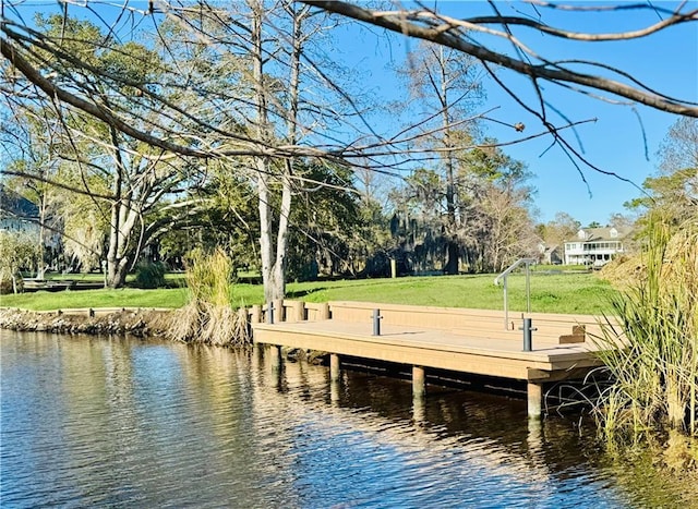 view of dock featuring a yard and a water view